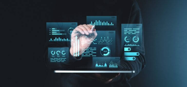 Persona interactuando con paneles digitales que muestran gráficos y métricas, ilustrando un flujo de trabajo de procesamiento por lotes en un entorno empresarial.