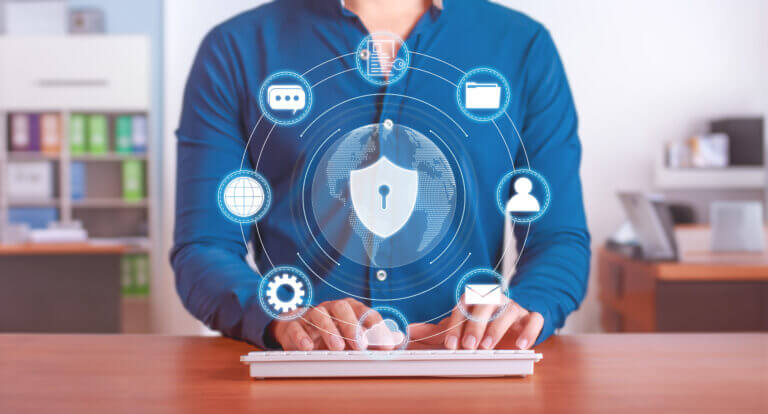 Ejecutivo usando teclado con íconos digitales de ciberseguridad que representan un plan de contingencia: protección de datos, usuarios, nube, correo y engranajes de control.