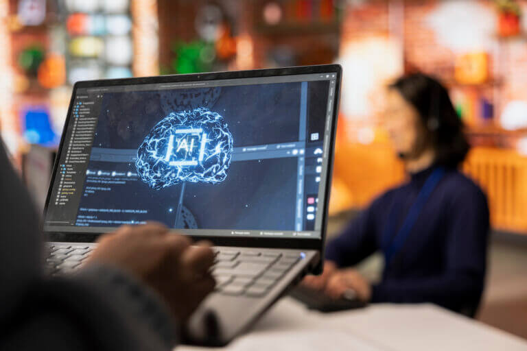 Pantalla de computadora mostrando un software con visualización de cerebro digital y letras IA, representando aplicaciones de IA en México en un entorno empresarial.