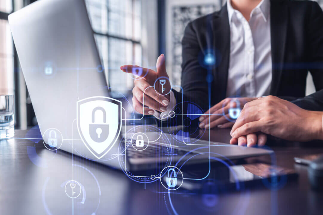 Ejecutivo trabajando en laptop con íconos digitales de candados y ciberseguridad. Representación visual de estrategias para proteger la información de la empresa frente a ciberamenazas.