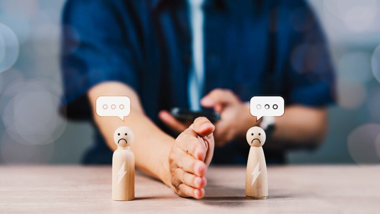 A,Man,Is,Holding,A,Cell,Phone,And,Two,Wooden