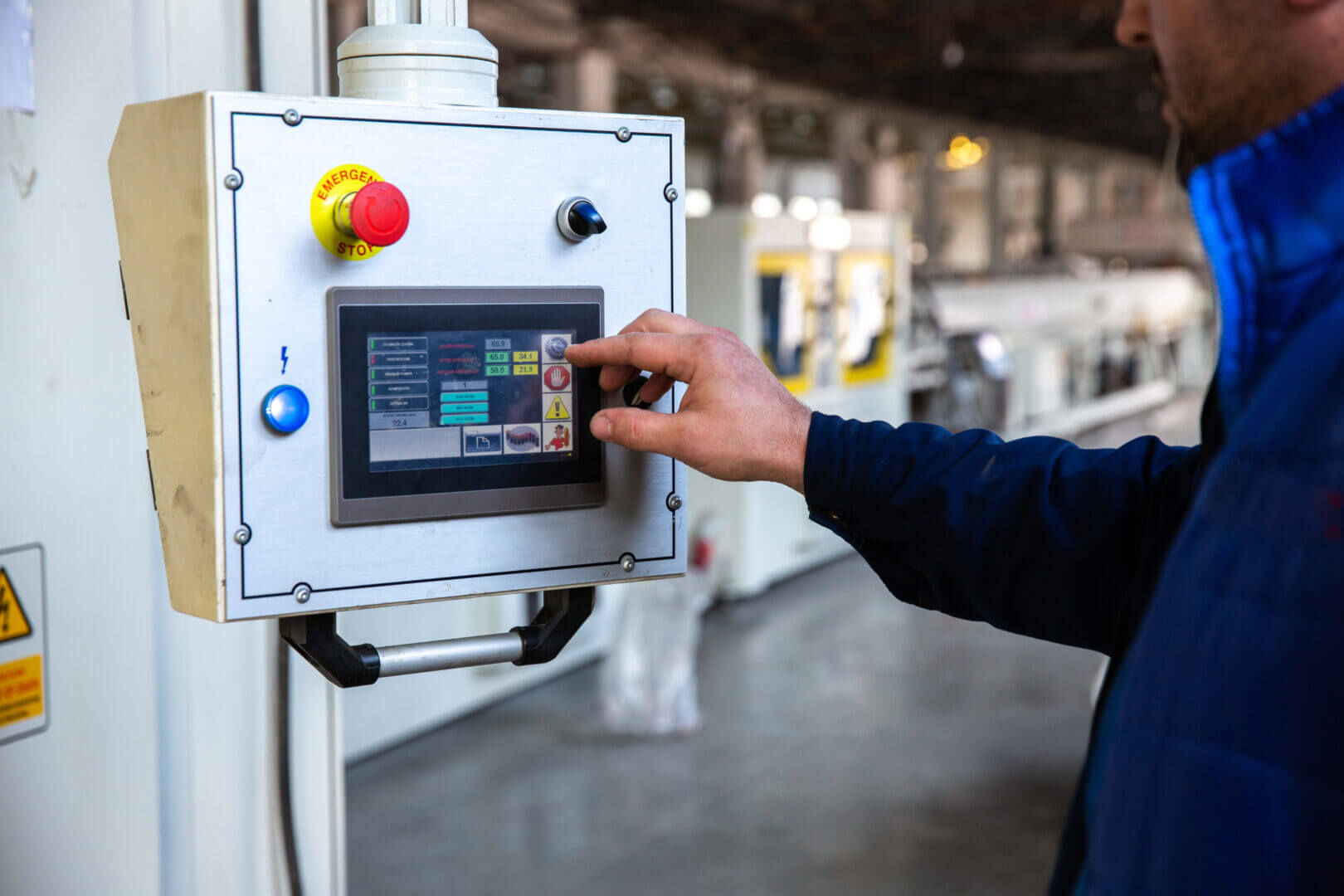 Operario tocando una pantalla de control digital en una máquina industrial, ilustrando la automatización y los tipos de Big Data aplicados a la industria.