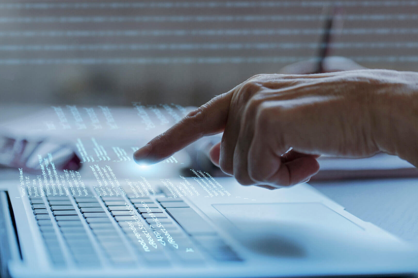 Mano tocando una pantalla digital con datos y código sobre un teclado, simbolizando la interacción humana con sistemas de Big Data.