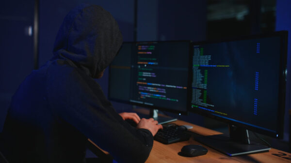 Hacker,Sitting,At,Desk,In,Dark,Atmosphere.,A,Computer,Programmer