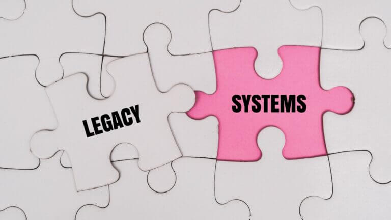 Piezas de rompecabezas unidas con las palabras Legacy y Systems, representando la integración de sistemas heredados en la era de la AI.