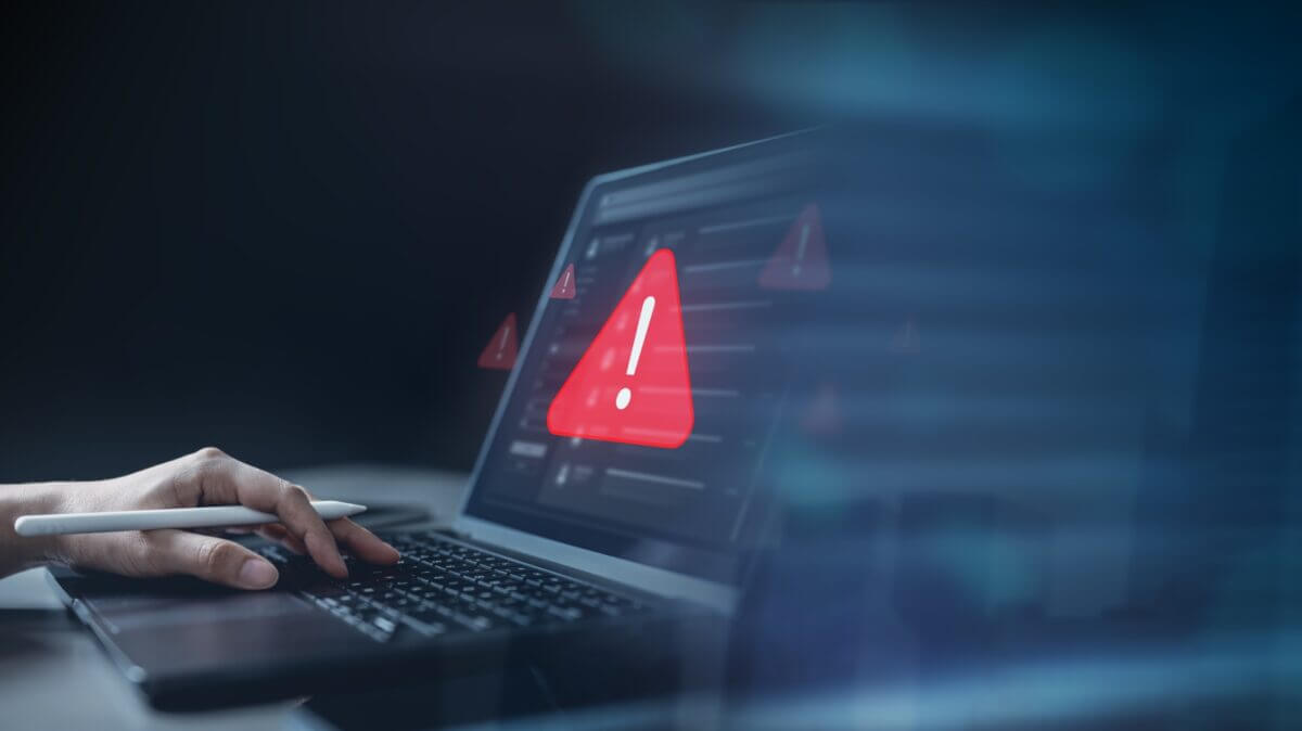Laptop mostrando una señal de alerta roja, ilustrando la filtración de credenciales Fortinet FortiBleed en redes empresariales.