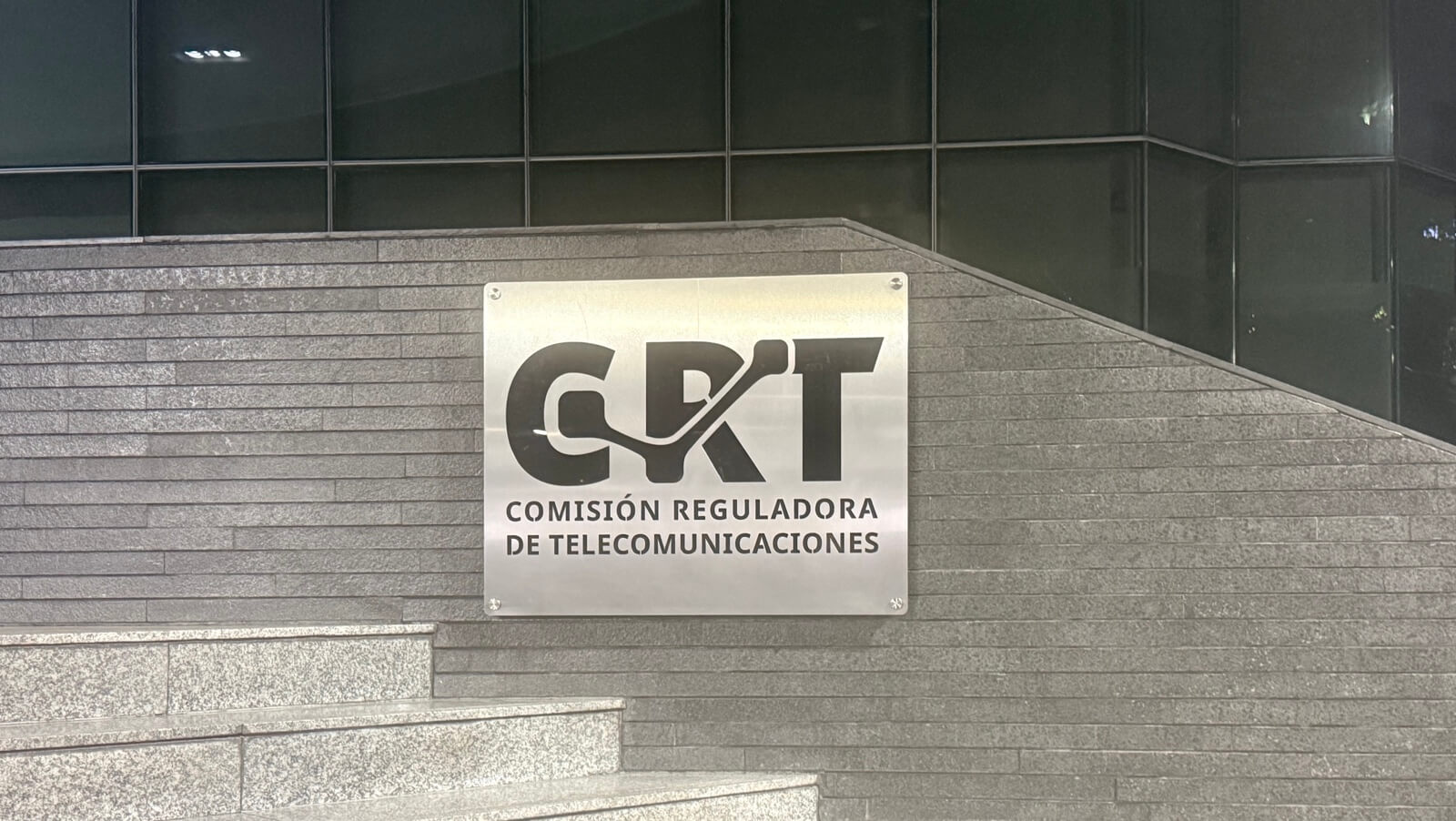 Placa metálica de la Comisión Reguladora de Telecomunicaciones para el artículo sobre registro de líneas de prepago CRT.