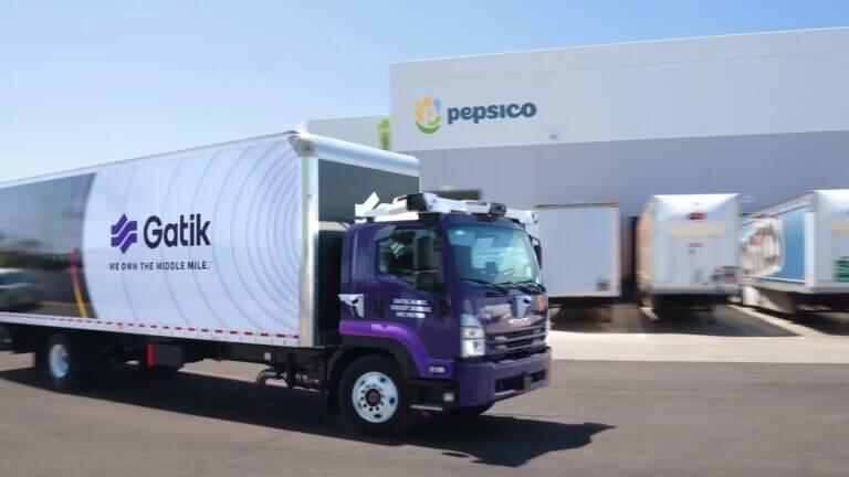 Camión Isuzu de Gatik AI saliendo de un centro de distribución, representando los vehículos autónomos de PepsiCo para la logística B2B.