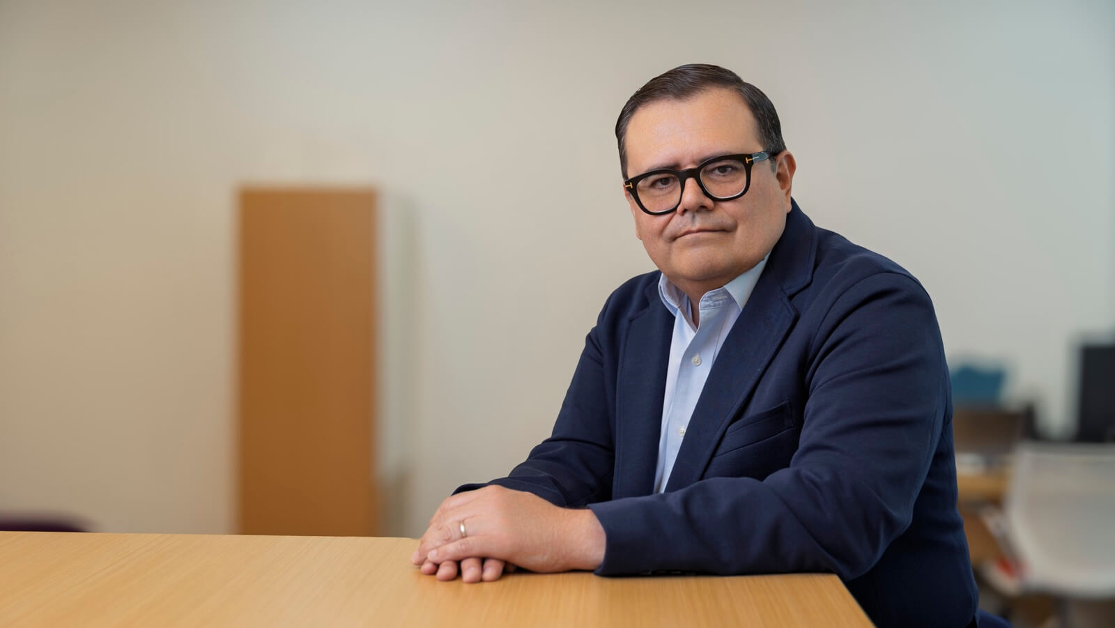 Gerardo Muñoz de brazos cruzados apoyado en una mesa, analizando la transformación digital de Liverpool.