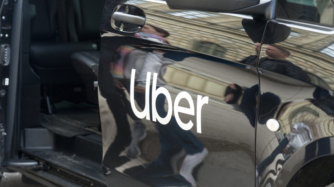 Vehículo negro con el logotipo de Uber impreso en la puerta lateral, ilustrando los recortes de personal por AI.