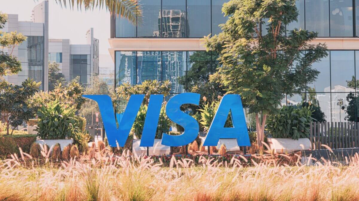 Logo gigante de Visa frente a sus oficinas tras anuncio de Visa despidos AI para reestructuración.
