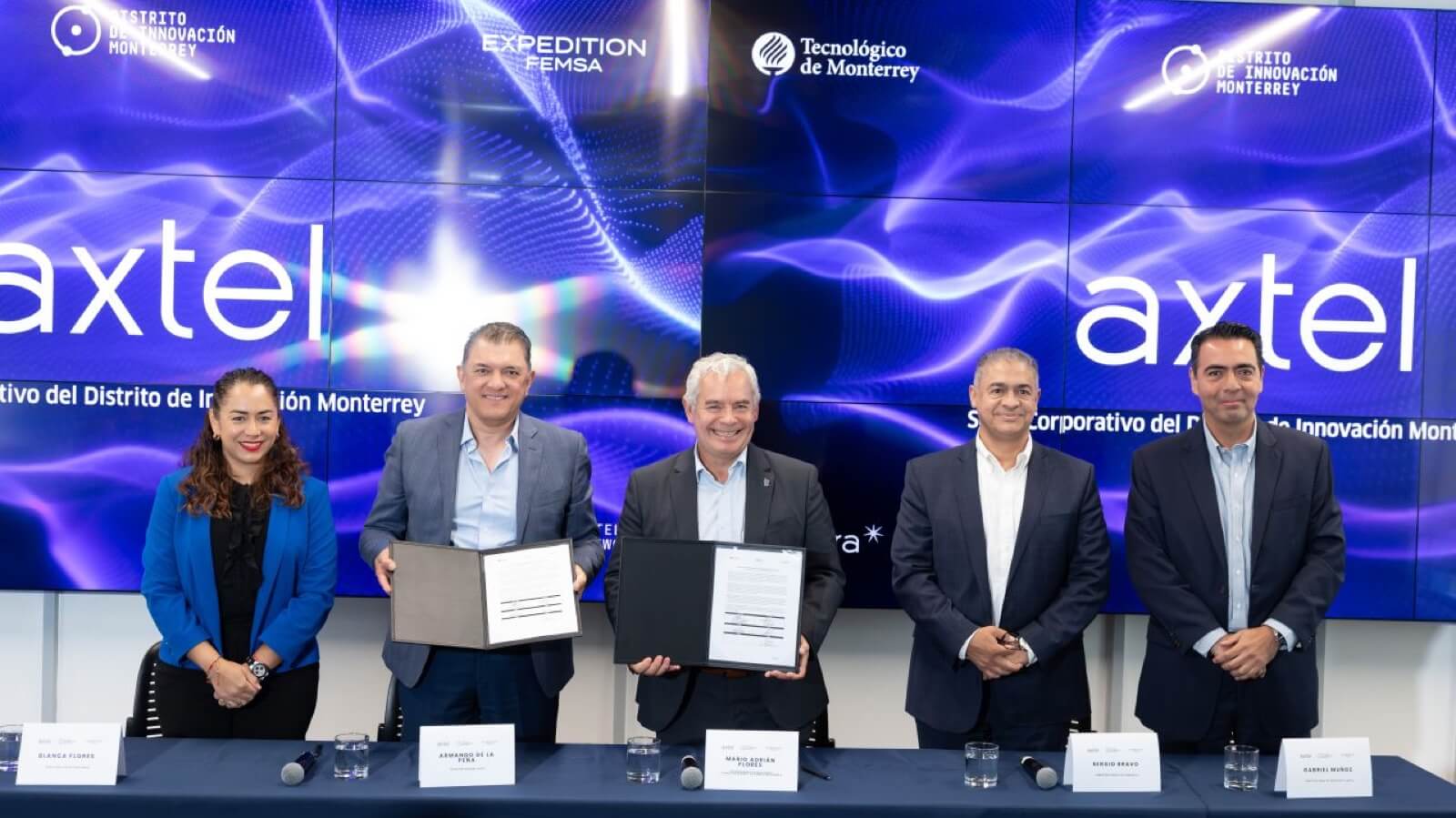 Directivos de Axtel y Tec de Monterrey muestran convenio tras firma de laboratorio AI.
