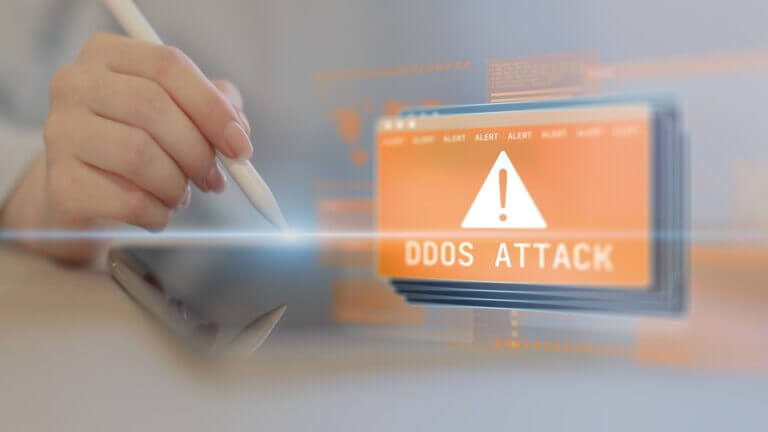 Mano con stylus señalando alerta digital de DDoS Attack, tema clave del reporte Cloudflare ataques DDoS 1 Tbps.