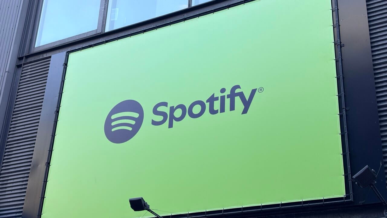 Gran cartel de Spotify sobre un edificio, compañía que optimiza sus costos de inteligencia artificial.