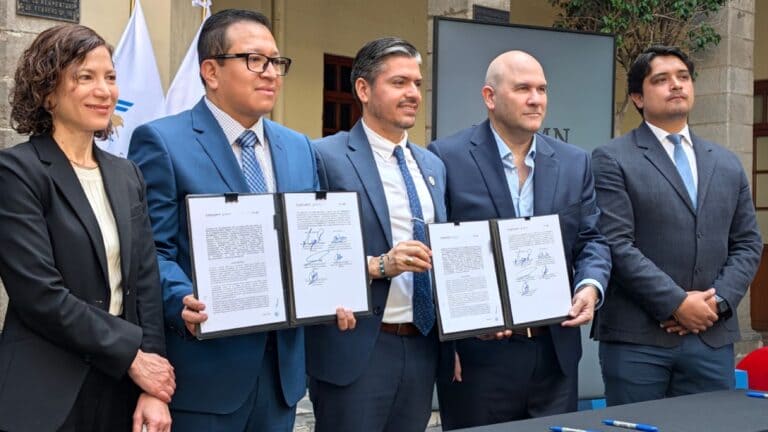 Representantes en la firma del convenio sobre Google AI meteorología México sostienen documentos firmados.